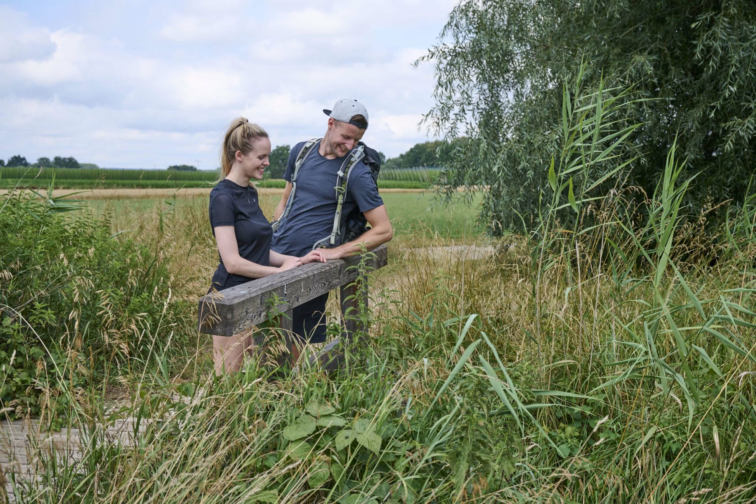 zwei Personen auf Wanderweg blickend in einen Bach