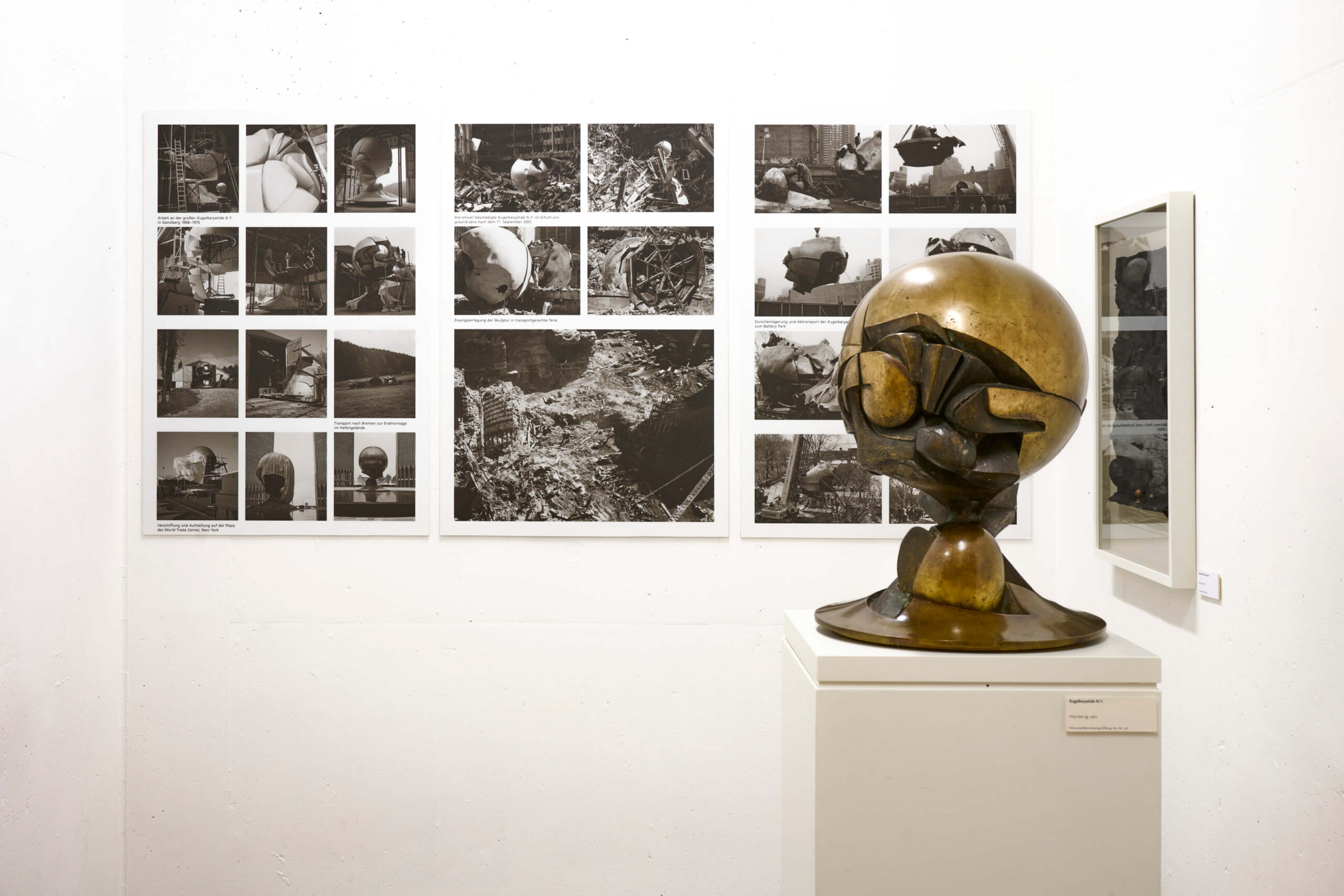 Skulptur vor einer Wand mit Bildern